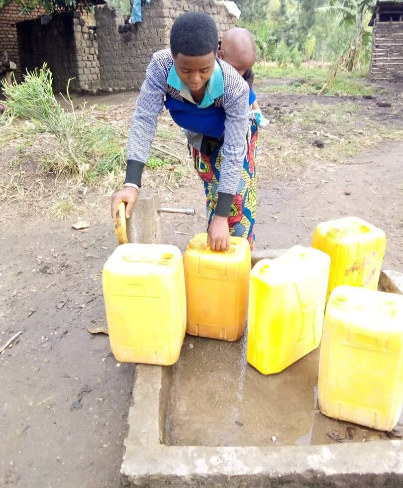 A woman filling jerrycans at one of the water pumps