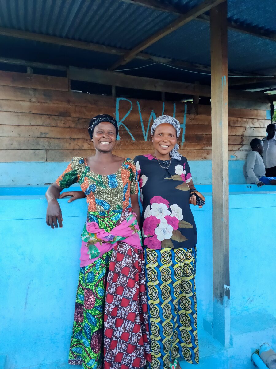 Two members in front of an RWH building